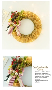 Detail of Christmas burlap wreath featuring red berries, pine cones, and warm LED lights
