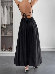 Detail of cross-back straps and pleated texture on a black maxi sundress