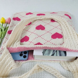 Detail of knit tote bag showing capacity with heart diamond pattern in beige and pink