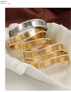 Detail of hollowed geometric bangles with pavé rhinestones in gold and silver finish