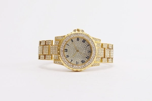 Front view of gold watch dial featuring roman numerals and sparkling crystal pavé setting