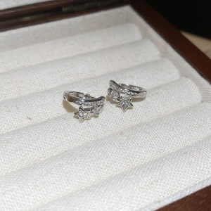 Gros plan de boucles d'oreilles étoile en argent avec zircons dans un coffret en bois