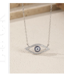 Dettaglio del pendente occhio in argento S925 con zirconi blu e catena a maglie fini