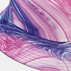 Macro detail of colorful tie-dye bucket hat featuring reinforced stitching and twill fabric