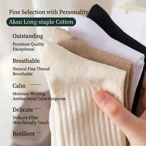 Chaussettes en coton côtelé doux aux tons neutres présentées en gros plan à la main