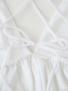 Detailed close-up of white dress bodice with elegant lace-up back and ruffled texture