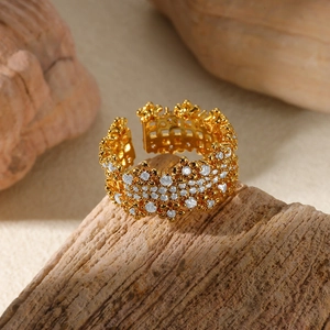 Detail of gold floral open ring with sparkling cubic zirconia on a rustic wooden texture