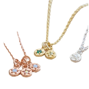 Three dainty necklaces in rose gold, gold, and silver with colorful gemstone pendants