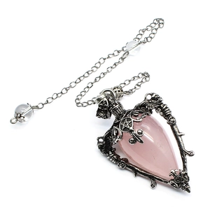 Macro detail of gothic rose and pentagram design on pink crystal teardrop pendant