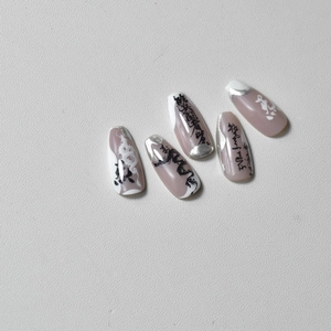 Macro shot of long trapezoid nails with Chinese calligraphy, silver edges and dragon patterns
