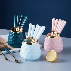 Three ceramic fruit fork storage jars in green, blue and pink with gold rimmed forks