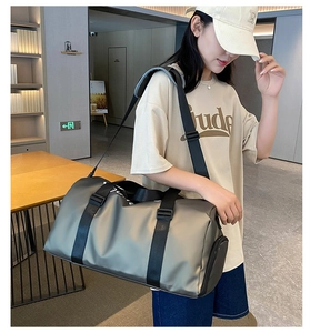 Gray travel bag with dry-wet separation carried by a model in a bright lobby setting