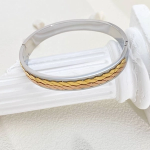 Close-up of three-tone stainless steel bangle with woven gold and rose gold star details