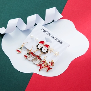 Detailed set of Christmas earrings featuring Santa, reindeer, and snowflakes on a festive card