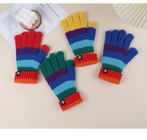 Macro detail of rainbow striped knit gloves with elastic cuffs and small black logo tag