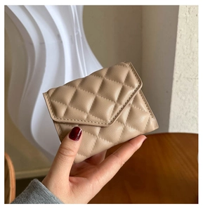 Close-up of beige quilted diamond pattern on a stylish PU leather women's clutch bag