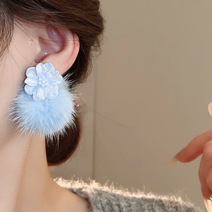 Detail of light blue floral resin stud with a soft faux fur pompom on model