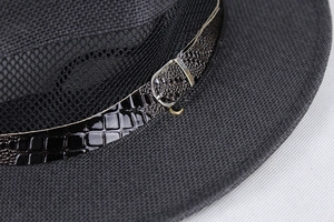Close-up of black straw fedora showing croc-embossed leather band and silver buckle