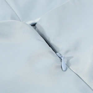 Detail view of smooth invisible zipper and premium twill fabric texture on light blue jumpsuit