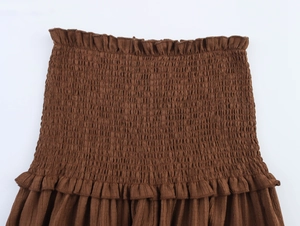 Close-up of dark brown shirred fabric texture with elastic smocking and ruffle edges