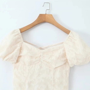 Abito crema con maniche a sbuffo, trama jacquard floreale e scollatura con lacci incrociati