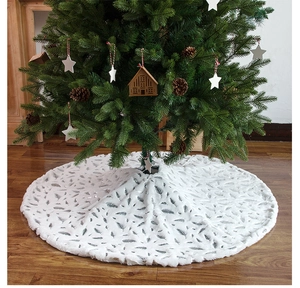 Detail of white faux fur Christmas tree skirt featuring elegant grey feather patterns