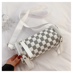 Detail of checkered cylinder bag with pleated texture and white fabric strap