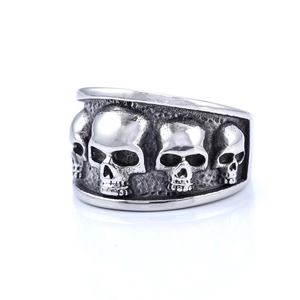 Detailed view of vintage silver skull ring with four embossed skulls and oxidized finish