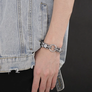 Macro detail of vintage silver skull charm on textured steel double layer chain
