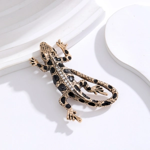 Retro lizard brooch with gold finish, black enamel spots and sparkling rhinestones