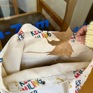 Detail view of corduroy tote bag interior with magnetic clasp and inner pockets