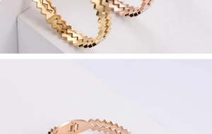 Macro detail of geometric zigzag bangles in gold and rose gold with pavé-set crystals