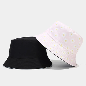 Detail view of cotton bucket hats in solid black and pink daisy floral print