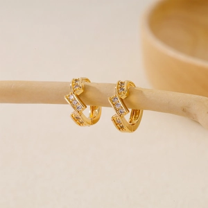 Detailed view of gold geometric hoop earrings with two rows of sparkling white zircons