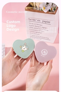 Close-up of portable heart-shaped makeup mirrors in mint green and light purple finishes