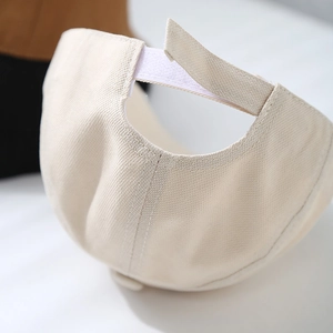 Detail of adjustable velcro strap on minimalist beige cotton kids beret cap