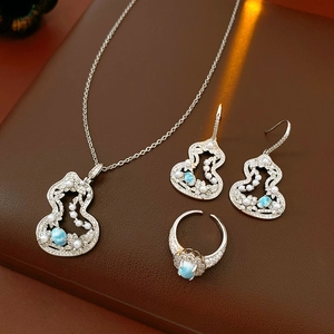 Macro view of zircon pearl gourd-shaped jewelry set with blue gemstones on leather