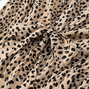 Detailed macro view of leopard print satin fabric texture and decorative bow tie knot