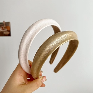 Detail shot of textured sponge headbands in white and gold finishes for women