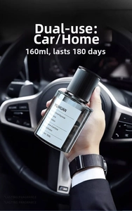 Hand holding a 160ml dark glass car fragrance bottle with plant-based extract liquid