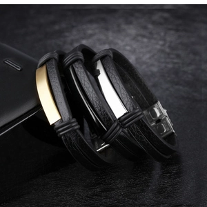 Detailed close-up of double-layer black leather bracelets with steel clasps in gold and silver