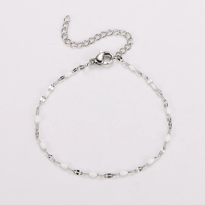Detailed view of silver stainless steel chain bracelet with white oval enamel beads