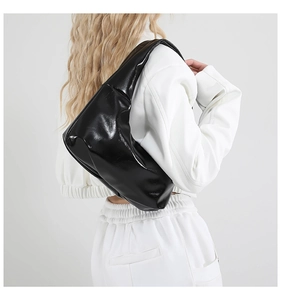 Schicke schwarze Lackleder-Hobo-Tasche am Model zeigt trendige Schulterpassform