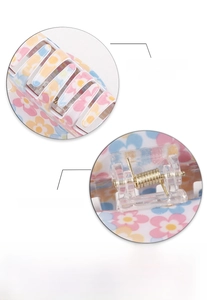 Detail showing smooth flower print surface and strong metal spring of the hair claw clip