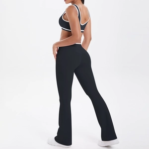 Detail view of high-waist flared yoga leggings and racerback sports bra with white piping