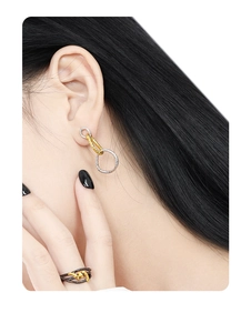 Close-up of S925 silver triple-ring earrings and layered black gold geometric ring