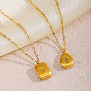 Golden stainless steel starburst pendant necklace set with zircon on silk background