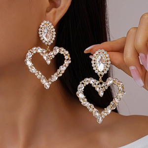 Close-up of large heart-shaped drop earrings with sparkling rhinestone crystals