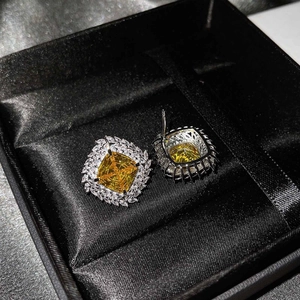 Detailed view of luxury square yellow gemstone stud earrings in a premium black gift box