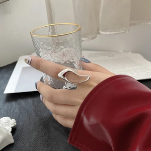 Irregular 925 sterling silver ring with abstract fluid design on model's hand